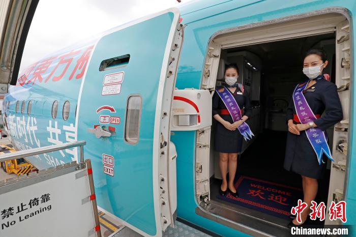 乘务员在全球首架“进博号”主题彩绘飞机客舱门口迎接旅客的到来。　殷立勤 摄