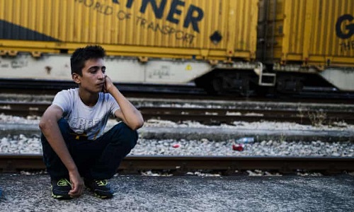 一名儿童移民在马其顿-希腊边境的格夫盖利亚等待火车前往塞尔维亚