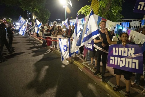 以色列左翼抗议者在以色列中部城市拉马特甘举行的组建新政府的示威活动中高呼口号并举着旗帜
