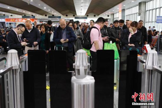 资料图：旅客等待验票进站。中新社记者 殷立勤 摄