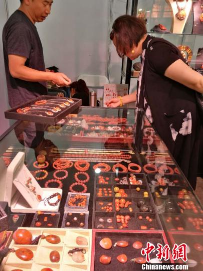 图为消费者在昆明国际石博览会上挑选南红制品。　胡远航 摄
