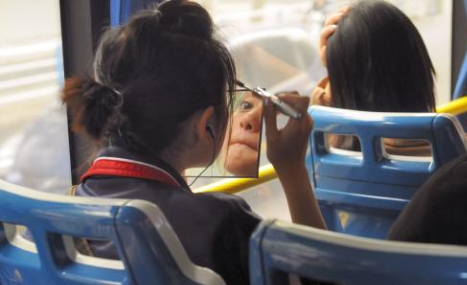 女市民在公交车上化妆