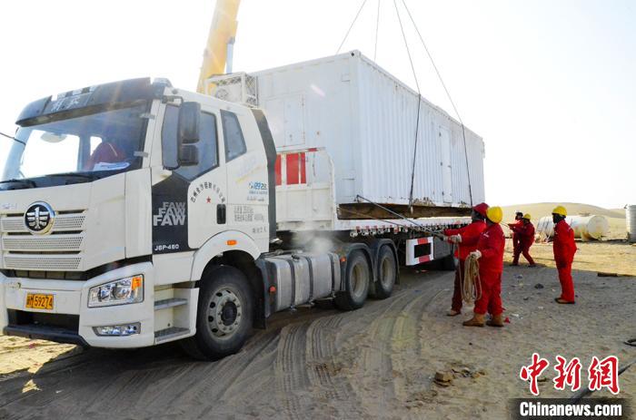 石油工人协助大型装载工具装车。　谭辉 摄