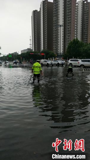 交警在积水严重路段排水。保定市交警支队供图