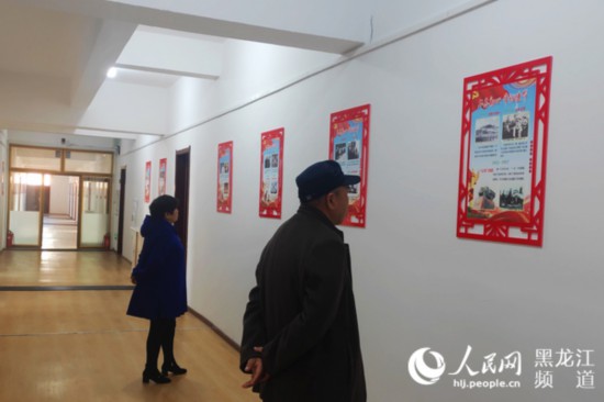 麻山区城镇助老活动中心，老人在走廊上阅读党建宣传内容。杨雪楠 摄