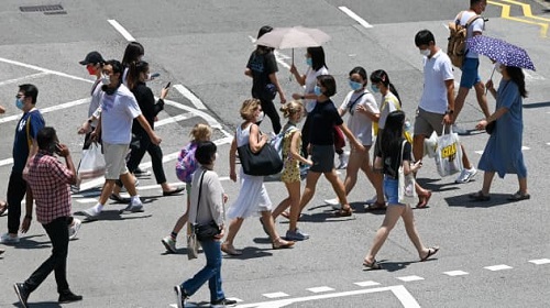 人们在新加坡乌节路购物区的人行横道上行走