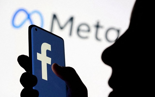 Facebook 新品牌标识 Meta 前手持带有 Facebook 标识的智能手机