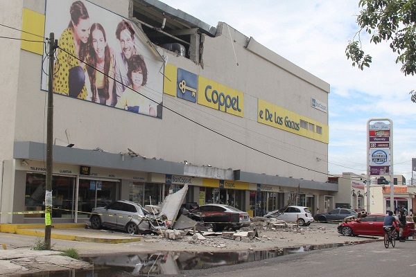 2022 年 9 月 19 日在墨西哥曼萨尼约的地震中，一家百货公司的外墙倒塌损坏了车辆