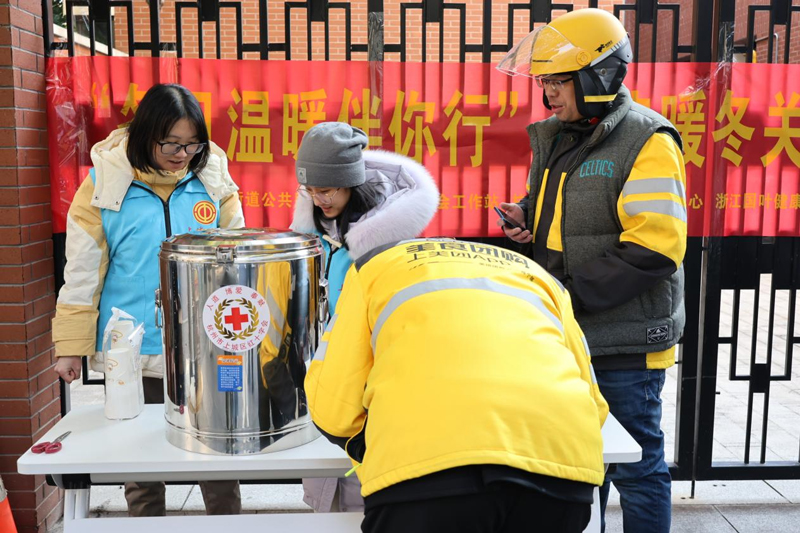 志愿者为户外劳动者送上姜茶。湖滨街道供图